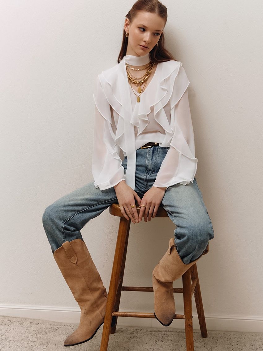 Blusa de gasa con volantes y lazo en el cuello.