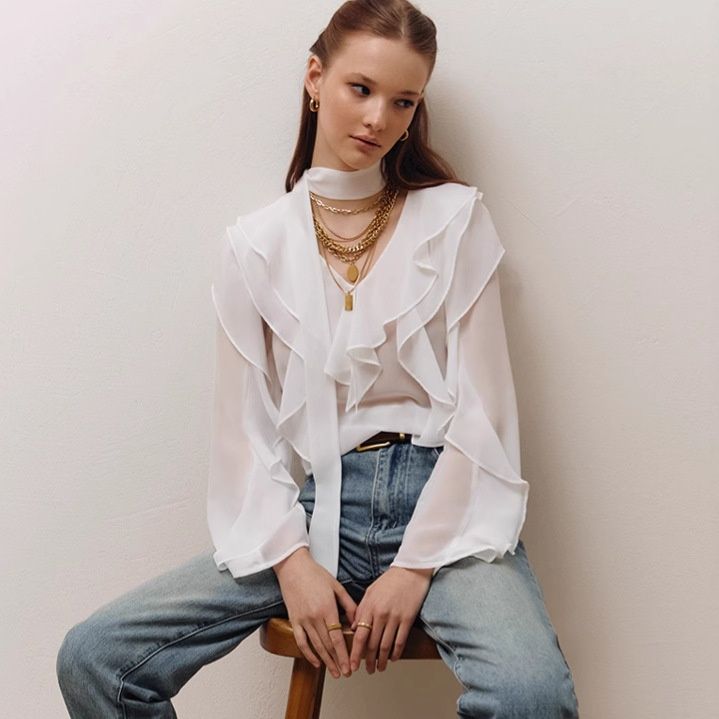 Blusa de gasa con volantes y lazo en el cuello.