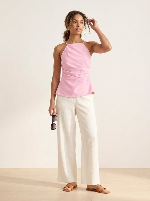 Top a canotta rosa con peplo drappeggiato e laccetti sul retro.