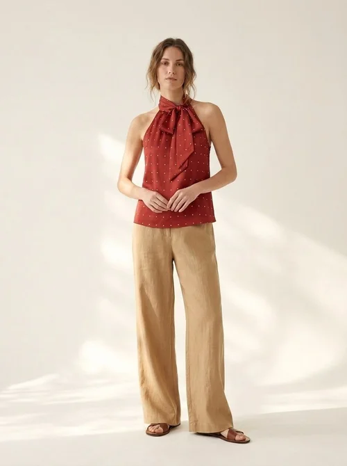 Camicetta a pois con scollo all'americana e laccetti da annodare al collo: chic e versatile.