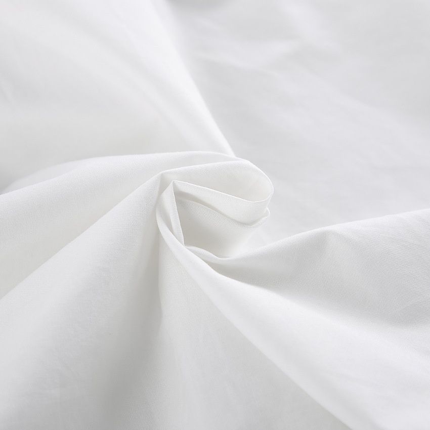 Elegante top blanco de un solo hombro con volantes.