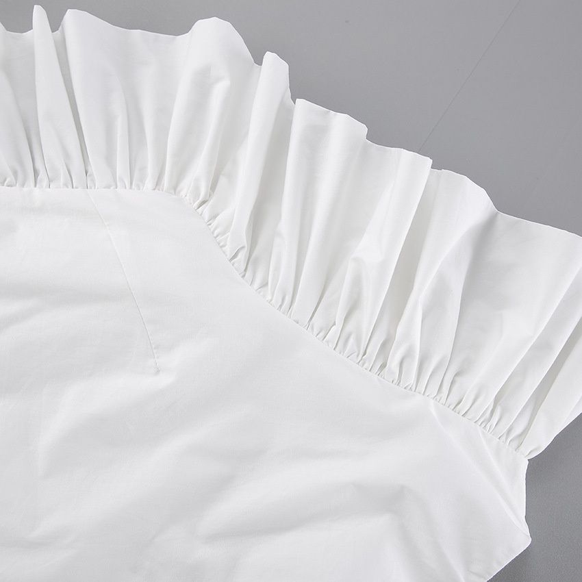 Elegante top blanco de un solo hombro con volantes.