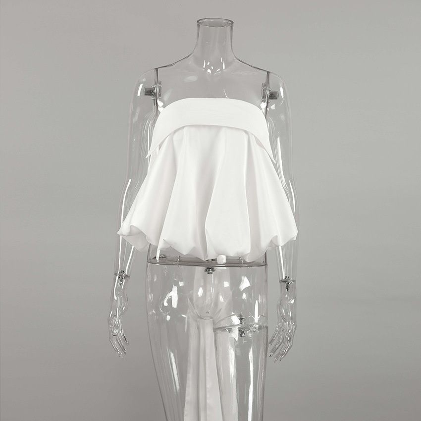 Top blanco sin tirantes con bajo abullonado y lazo largo en la espalda.