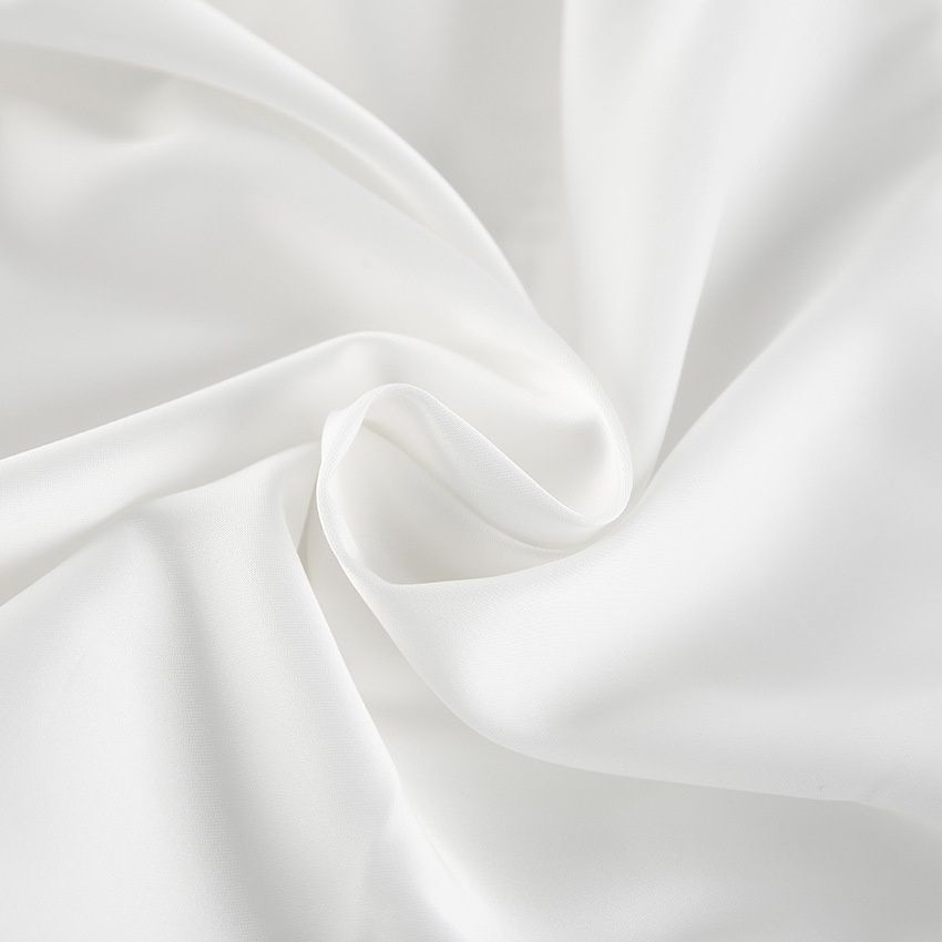 Top blanco sin tirantes con bajo abullonado y lazo largo en la espalda.