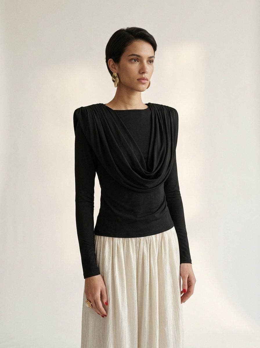 Elegante top de manga larga con cuello drapeado y hombreras acolchadas.