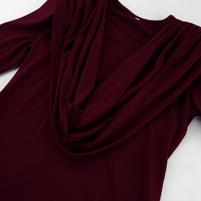 Elegante top de manga larga con cuello drapeado y hombreras acolchadas.