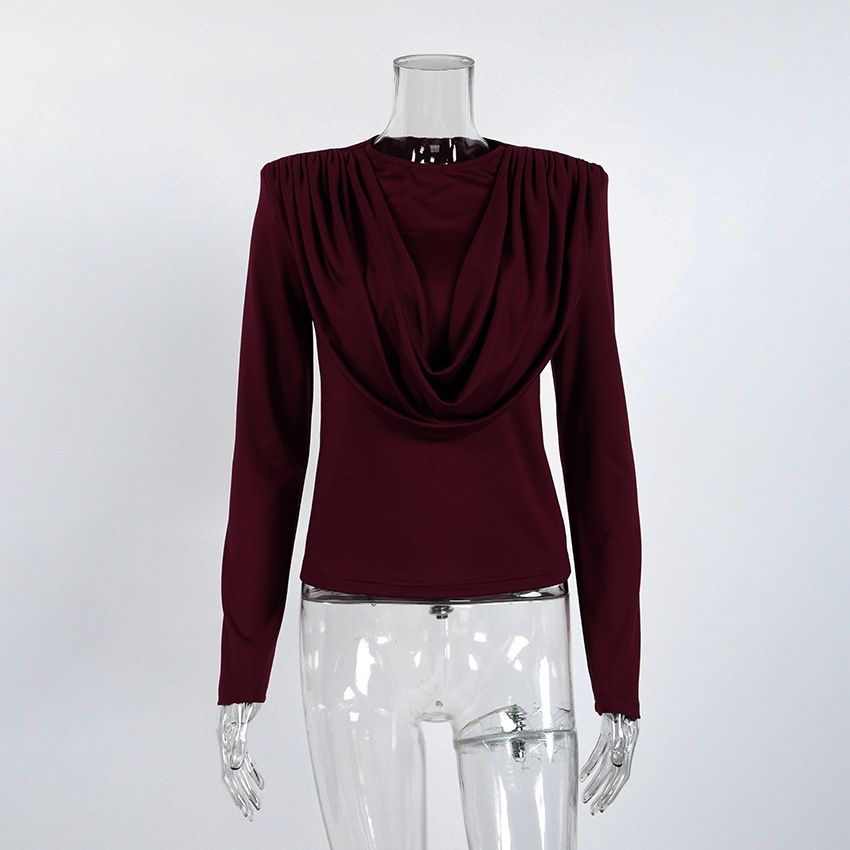 Elegante top de manga larga con cuello drapeado y hombreras acolchadas.