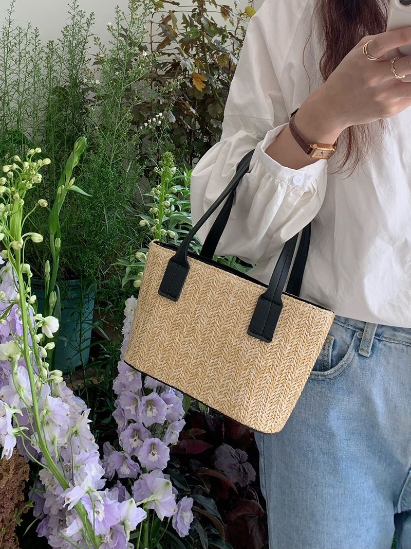 Minibolso elegante de paja tejida con forro de cordón ajustable.