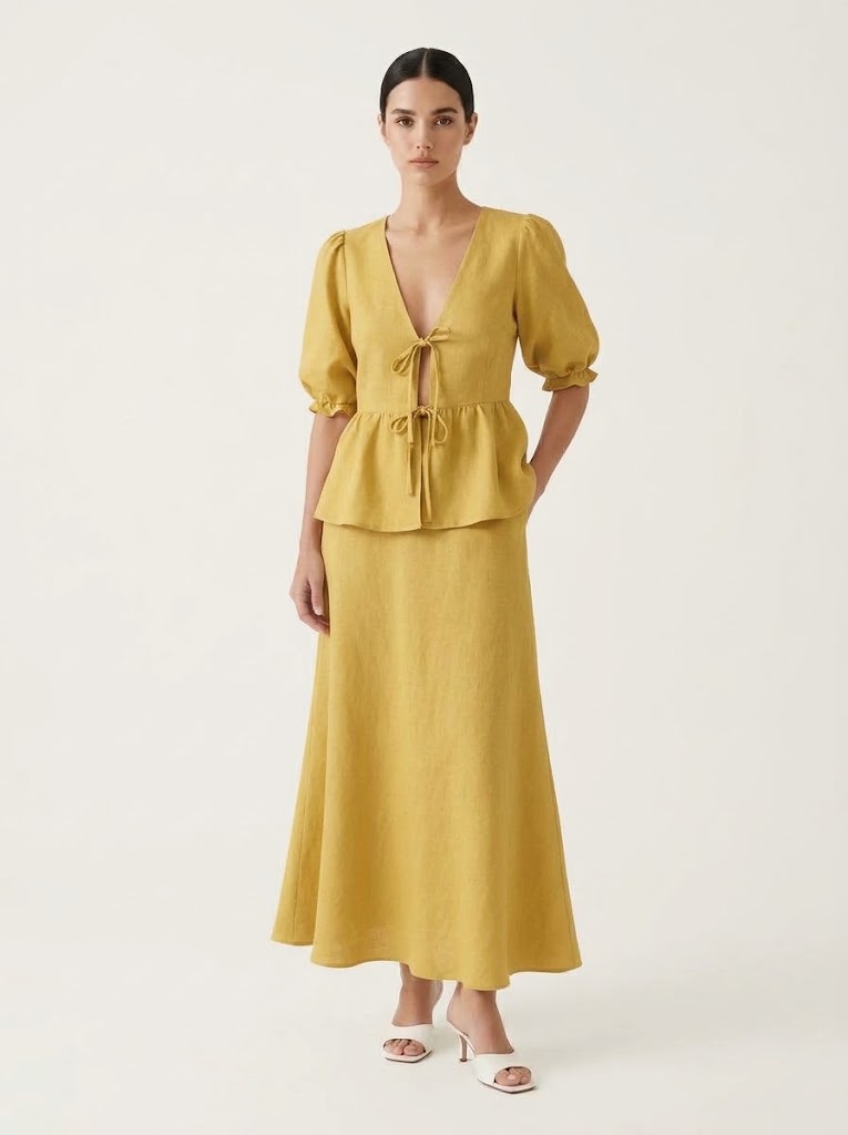 Completo giallo composto da top peplum con maniche a sbuffo e gonna lunga.