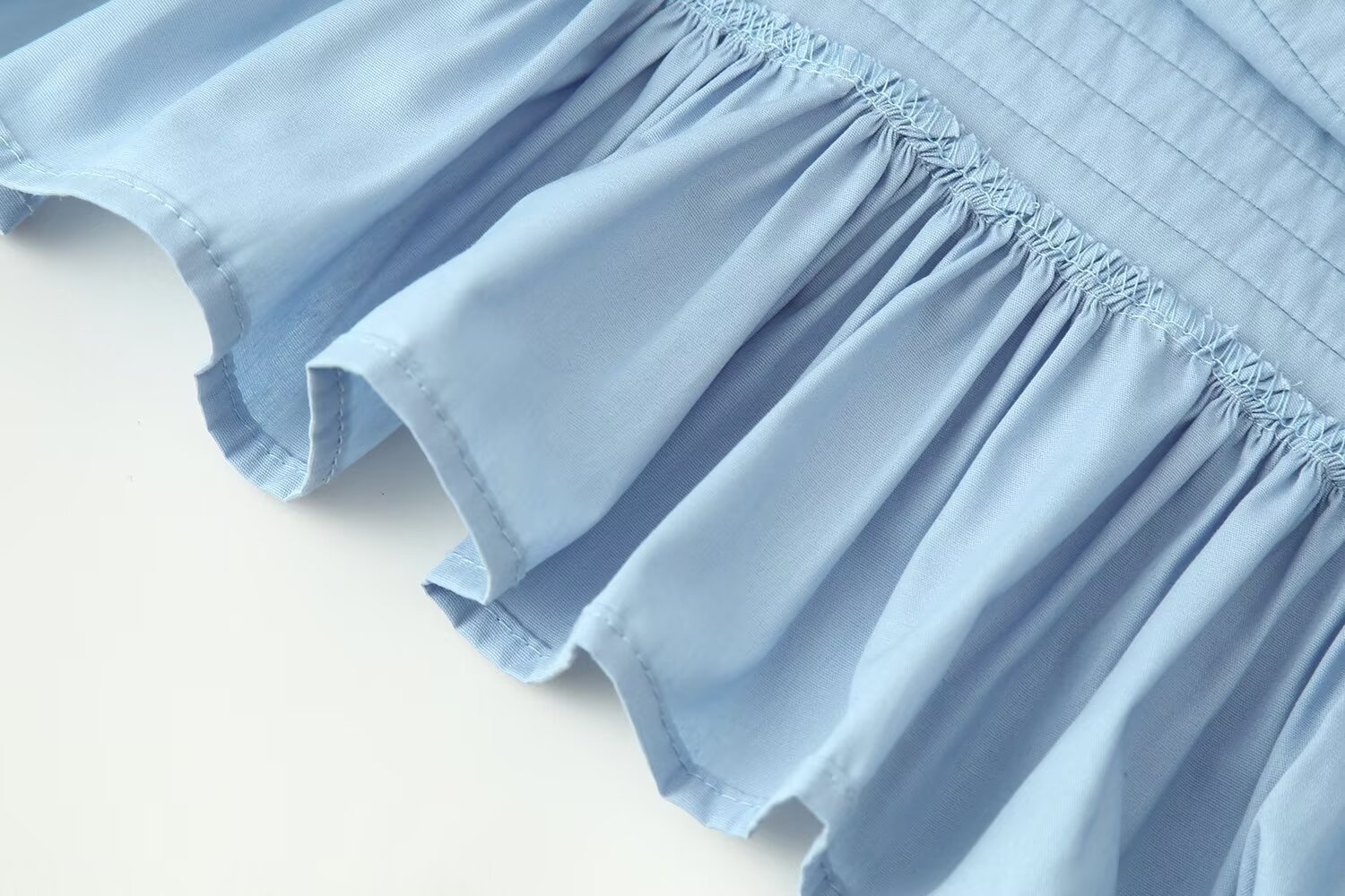 Elegante camicetta con orlo a balze e maniche a volant, caratterizzata da arricciature.