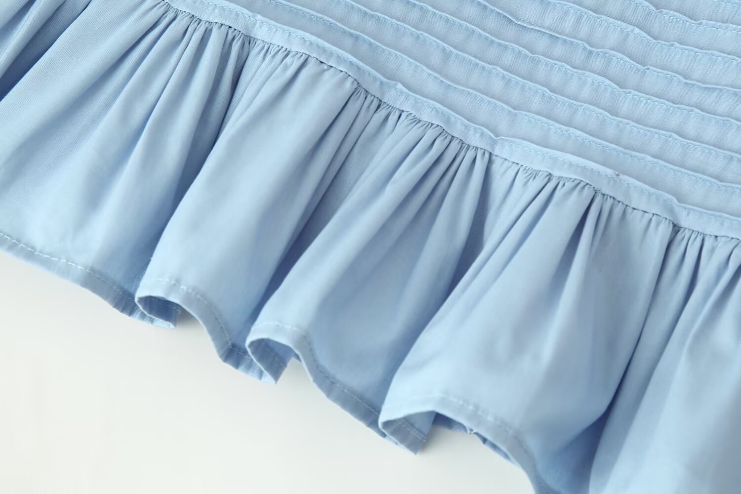 Elegante camicetta con orlo a balze e maniche a volant, caratterizzata da arricciature.