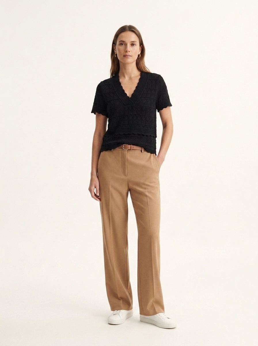 Elegante top a maniche corte con scollo a V e orlo smerlato, in maglia traforata.