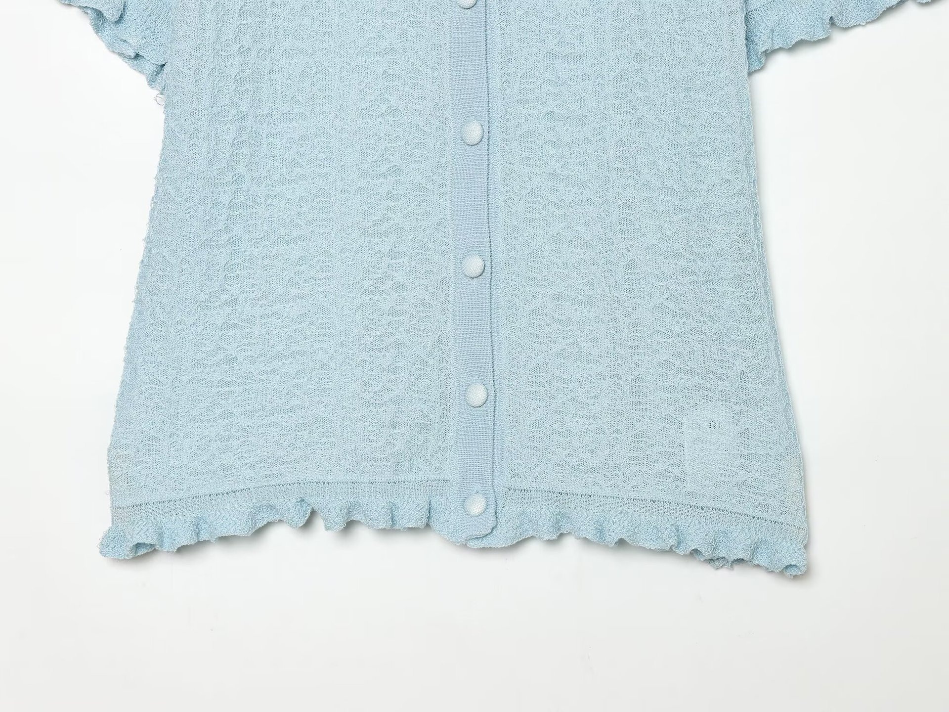 Cardigan chic a maniche corte con texture e volant.