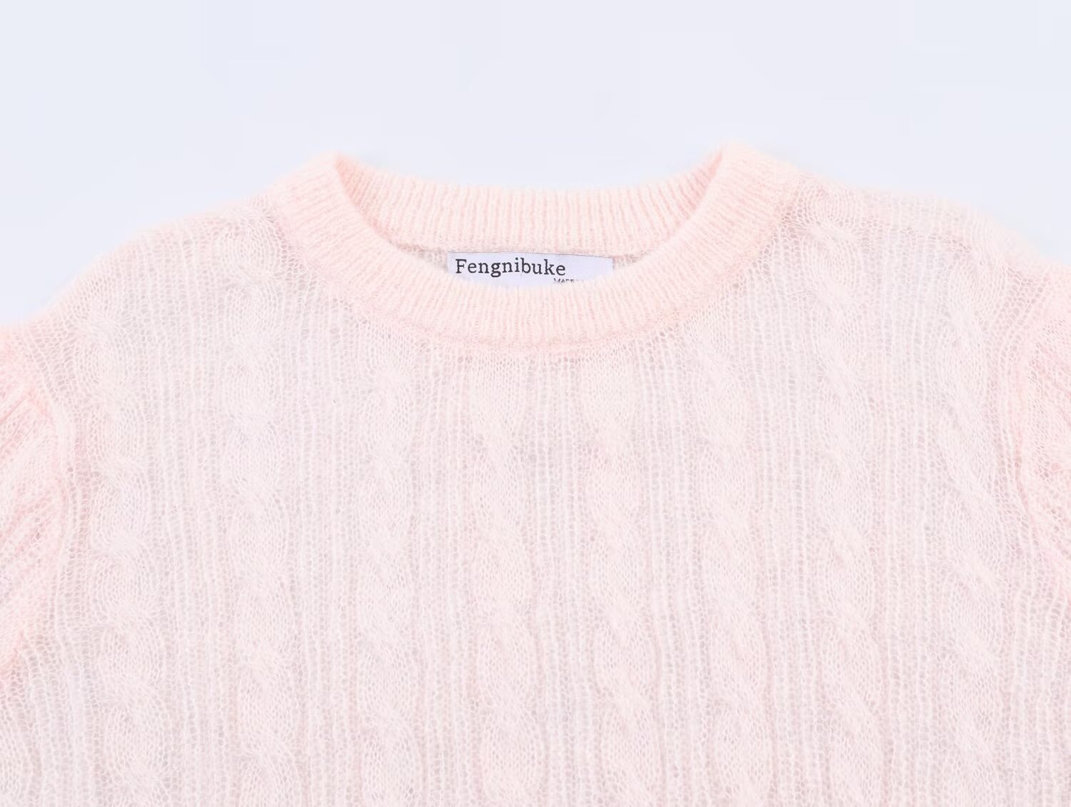 Elegante top rosa chiaro in maglia a trecce con maniche a sbuffo trasparenti.