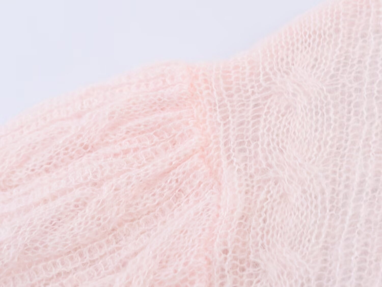 Elegante top rosa chiaro in maglia a trecce con maniche a sbuffo trasparenti.