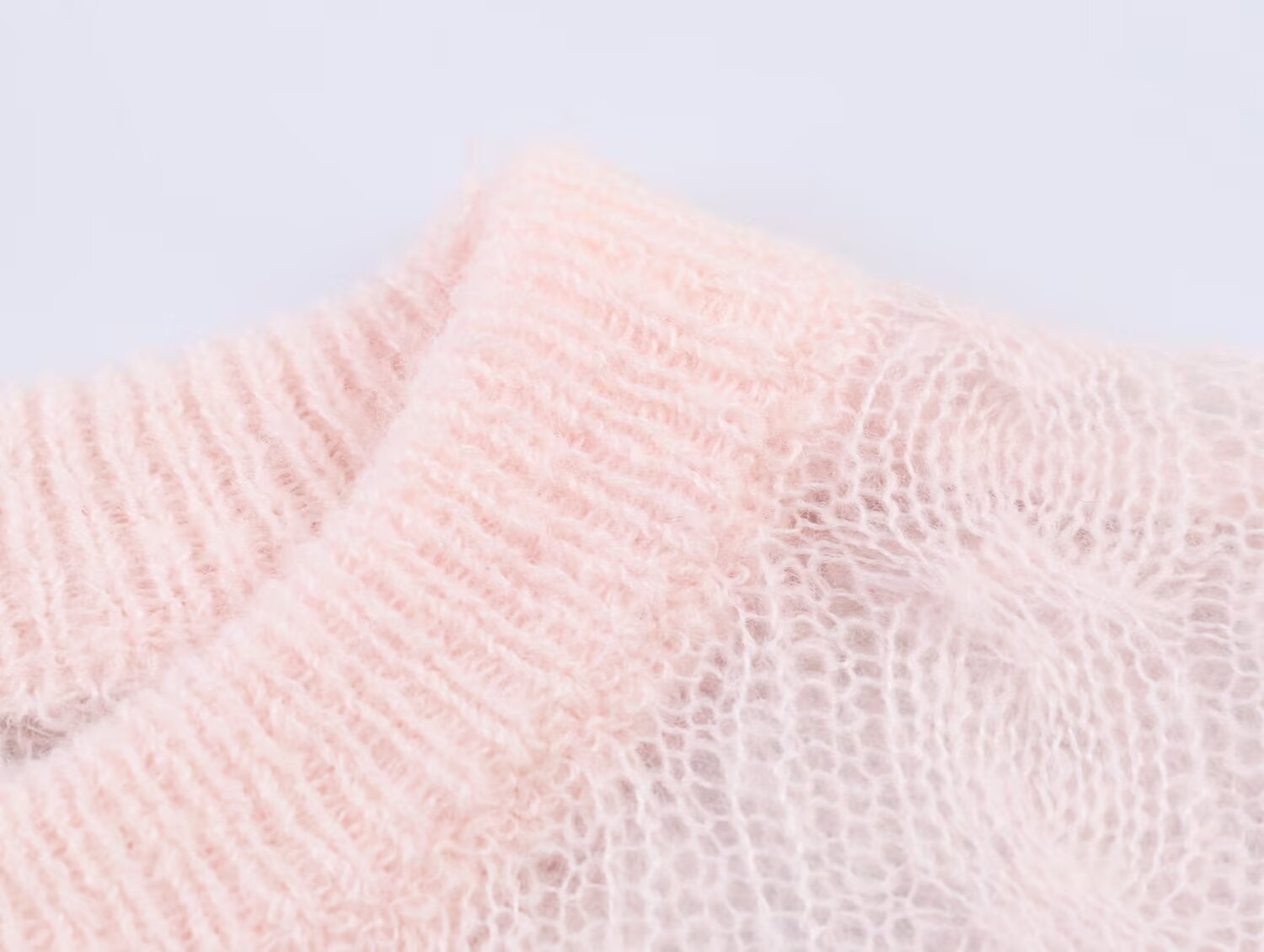 Elegante top rosa chiaro in maglia a trecce con maniche a sbuffo trasparenti.