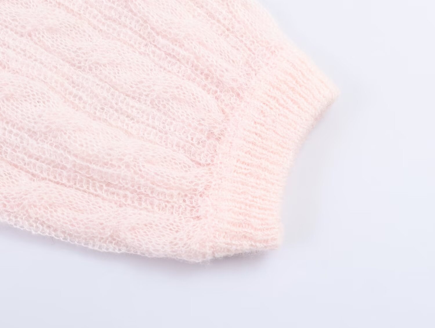Elegante top rosa chiaro in maglia a trecce con maniche a sbuffo trasparenti.