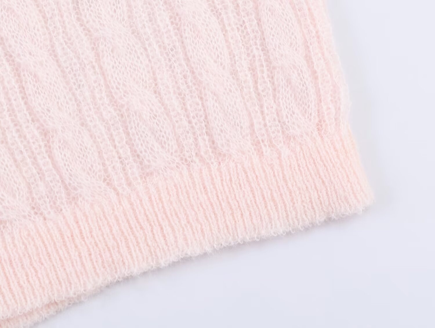Elegante top rosa chiaro in maglia a trecce con maniche a sbuffo trasparenti.