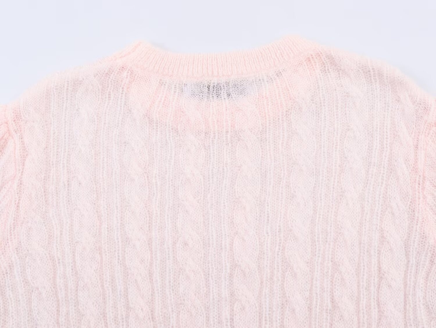 Elegante top rosa chiaro in maglia a trecce con maniche a sbuffo trasparenti.