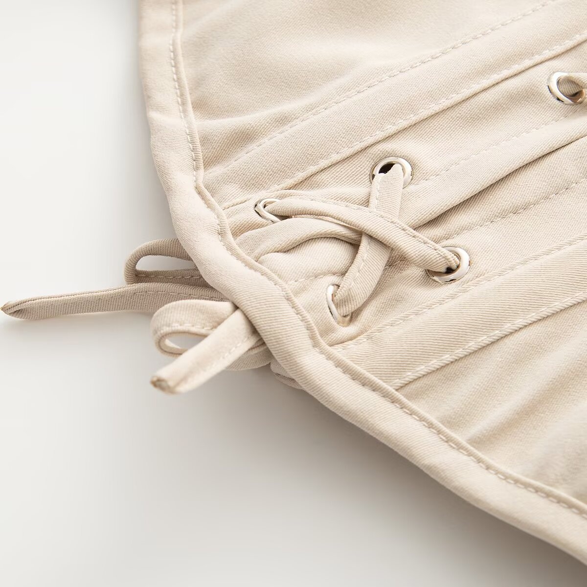 Elegante top a corsetto senza spalline con stecche, color beige.