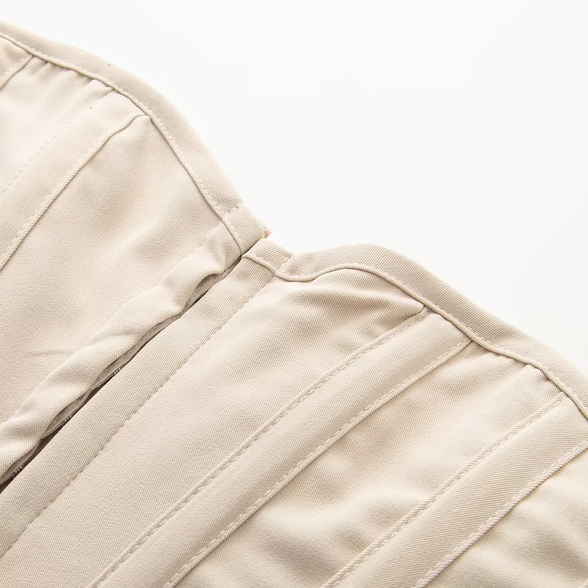 Elegante top a corsetto senza spalline con stecche, color beige.