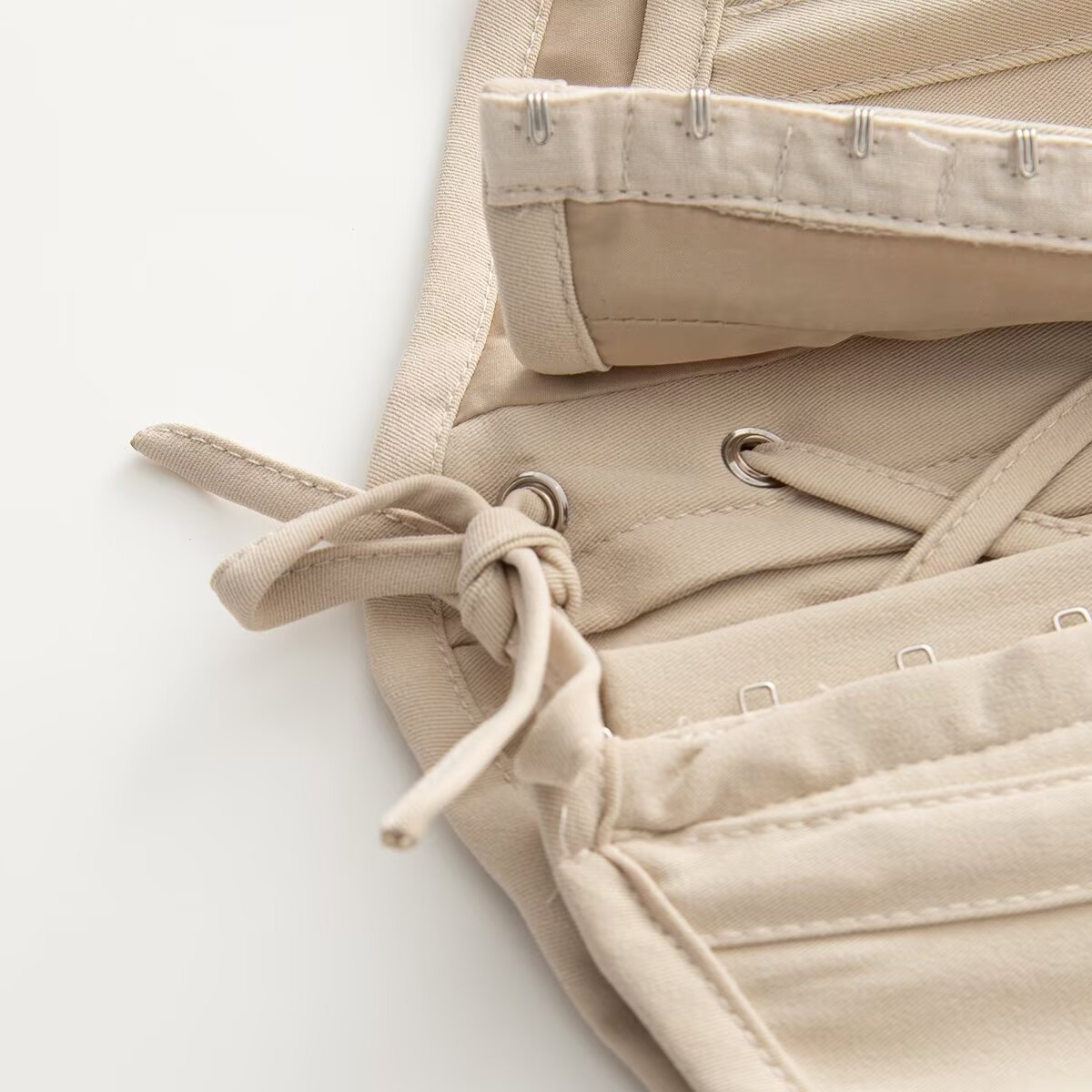 Elegante top a corsetto senza spalline con stecche, color beige.