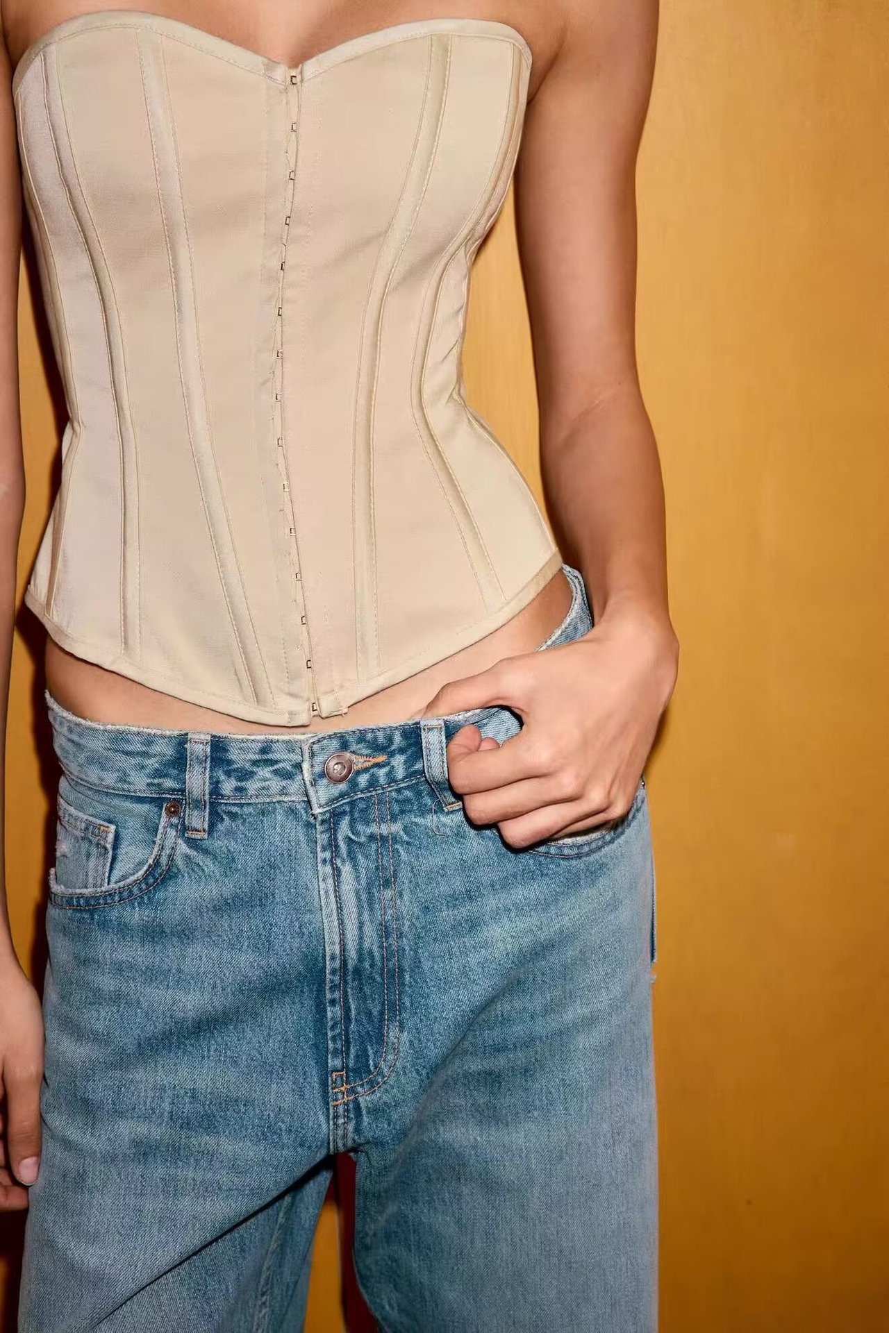 Elegante top a corsetto senza spalline con stecche, color beige.