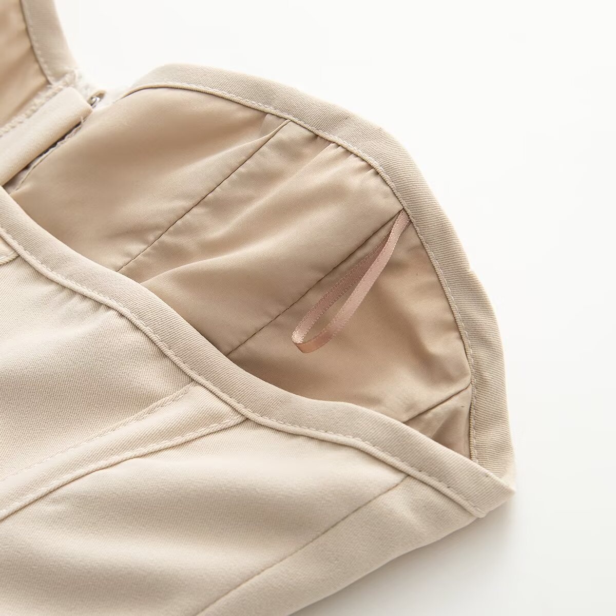 Elegante top a corsetto senza spalline con stecche, color beige.