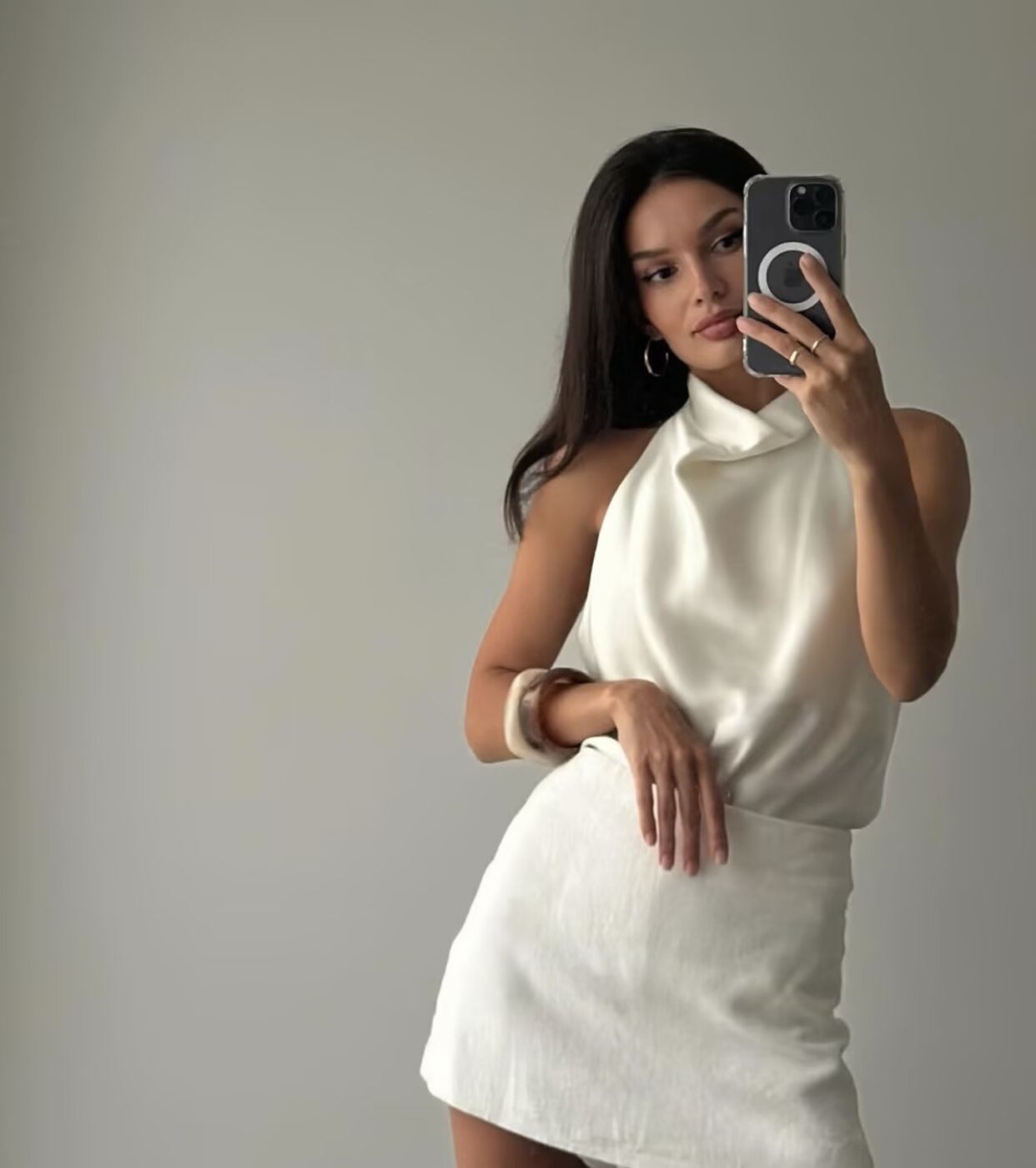 Elegante top da donna in raso con scollo all'americana e drappeggio a cascata.