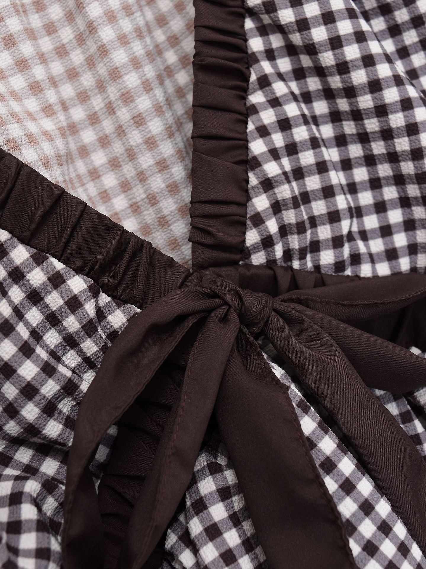 Elegante camicetta peplum a quadretti vichy con fiocco e maniche a sbuffo.