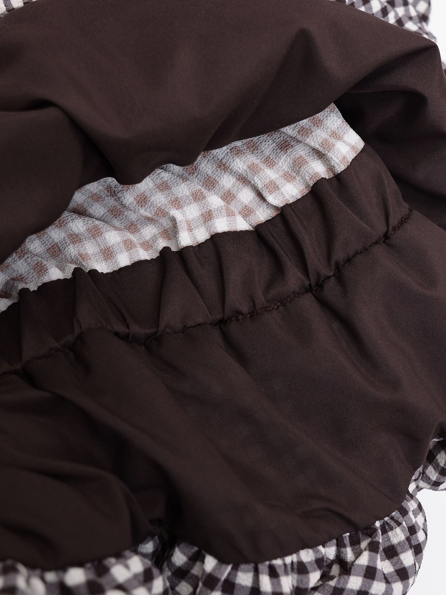 Elegante camicetta peplum a quadretti vichy con fiocco e maniche a sbuffo.