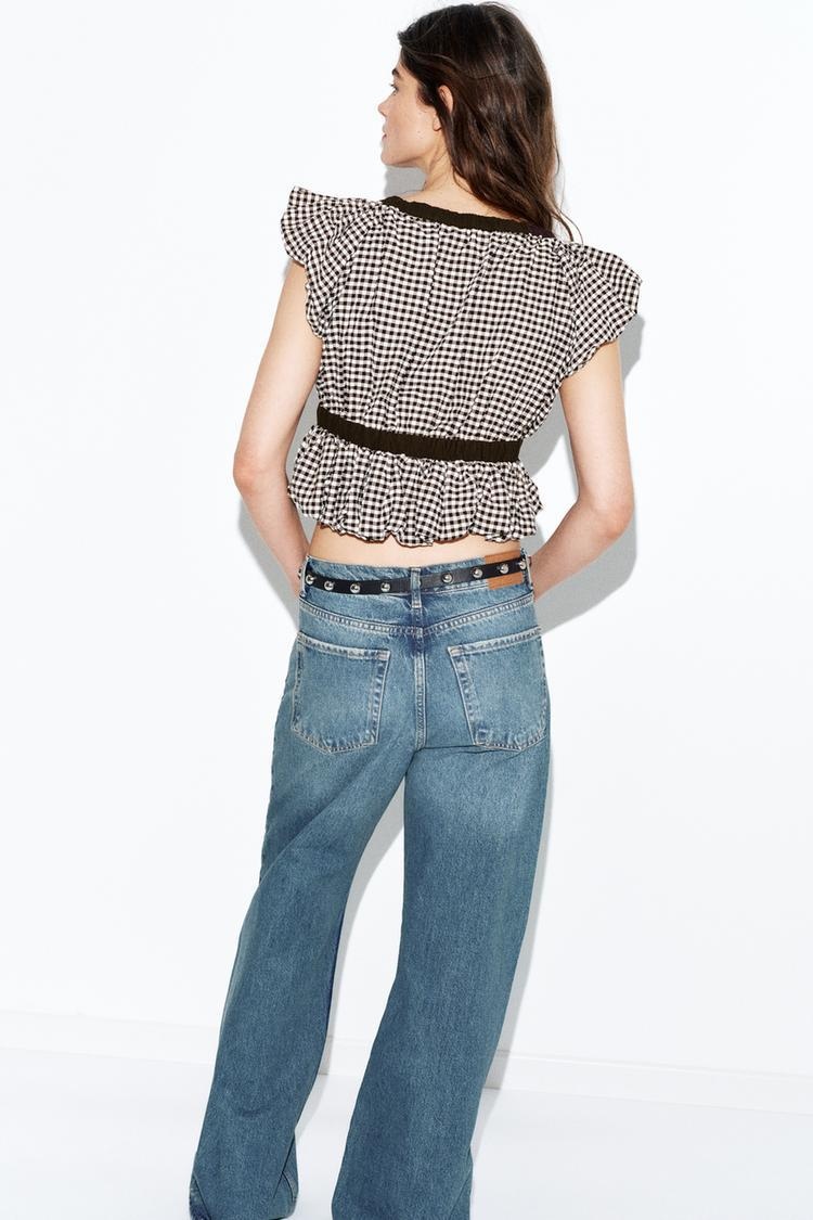Elegante camicetta peplum a quadretti vichy con fiocco e maniche a sbuffo.
