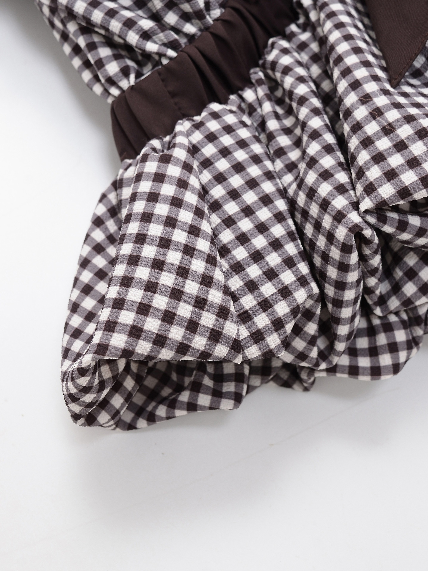 Elegante camicetta peplum a quadretti vichy con fiocco e maniche a sbuffo.
