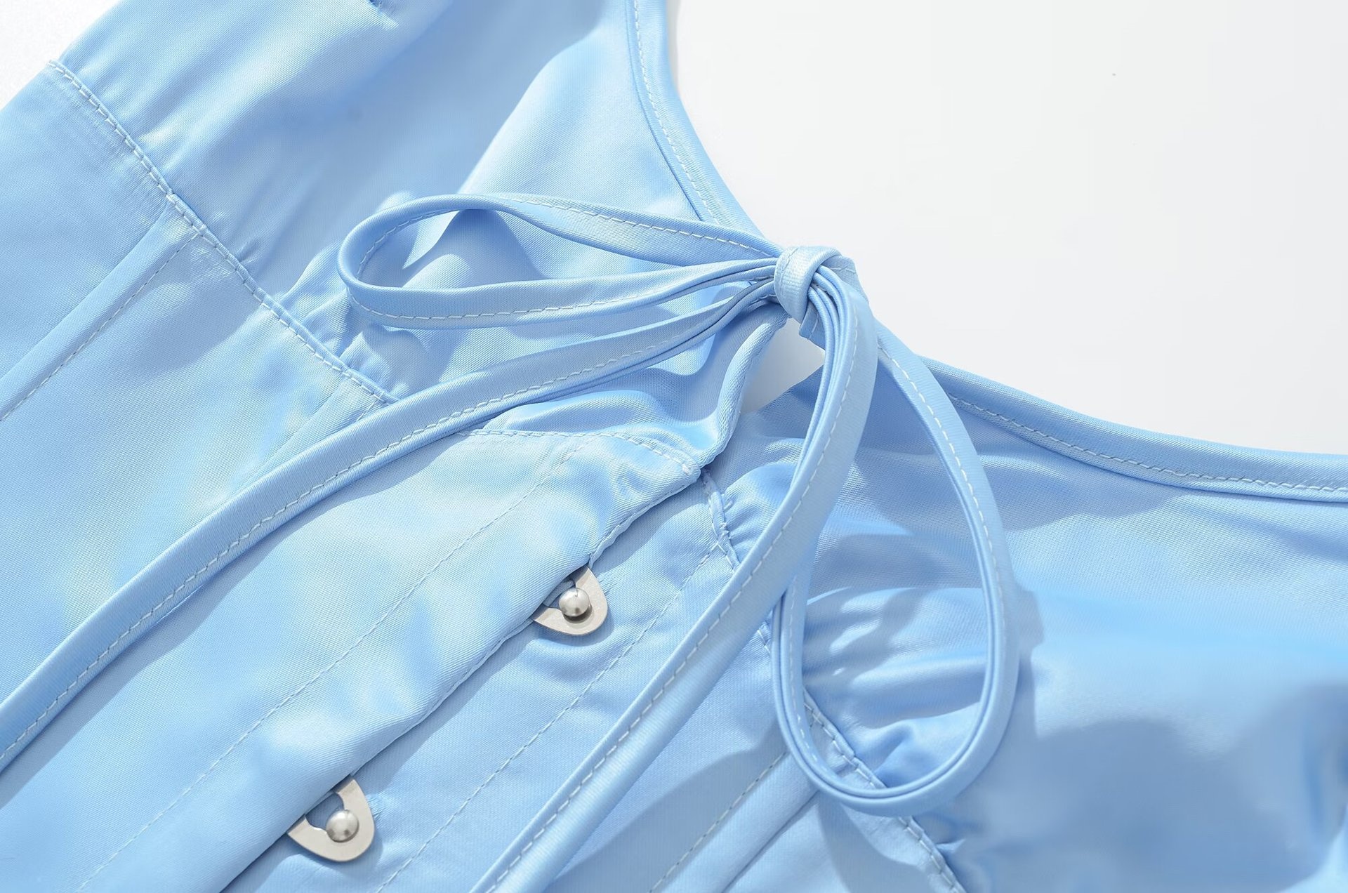 Top a corsetto in raso azzurro cielo con allacciatura al collo e lacci sul retro.