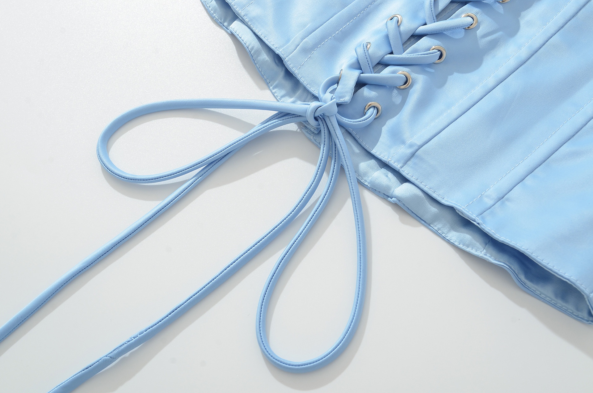 Top a corsetto in raso azzurro cielo con allacciatura al collo e lacci sul retro.