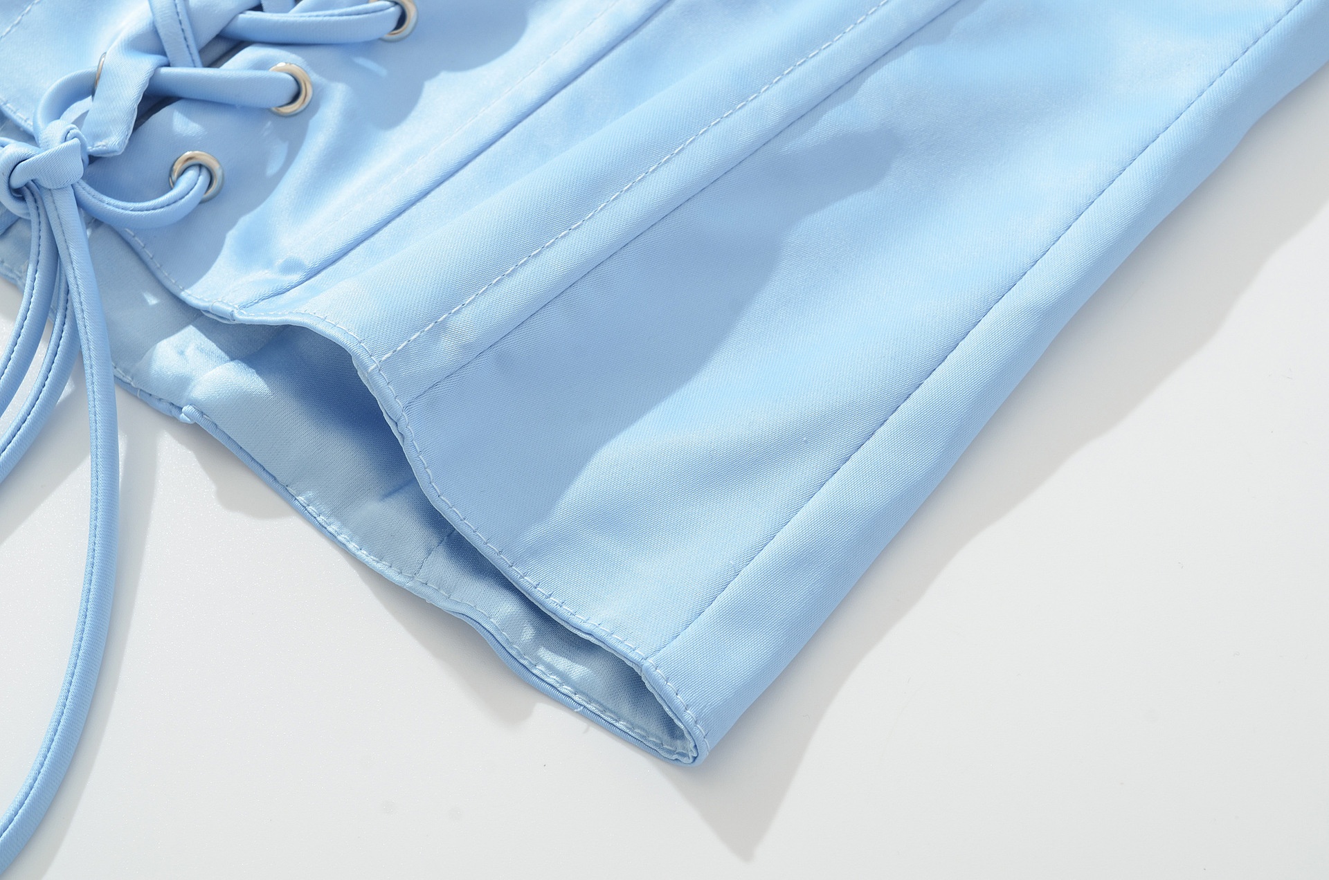 Top a corsetto in raso azzurro cielo con allacciatura al collo e lacci sul retro.