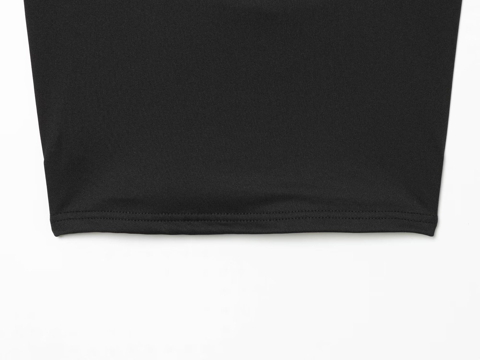 Elegante crop top nero con scollo all'americana e dettaglio ad anello dorato.