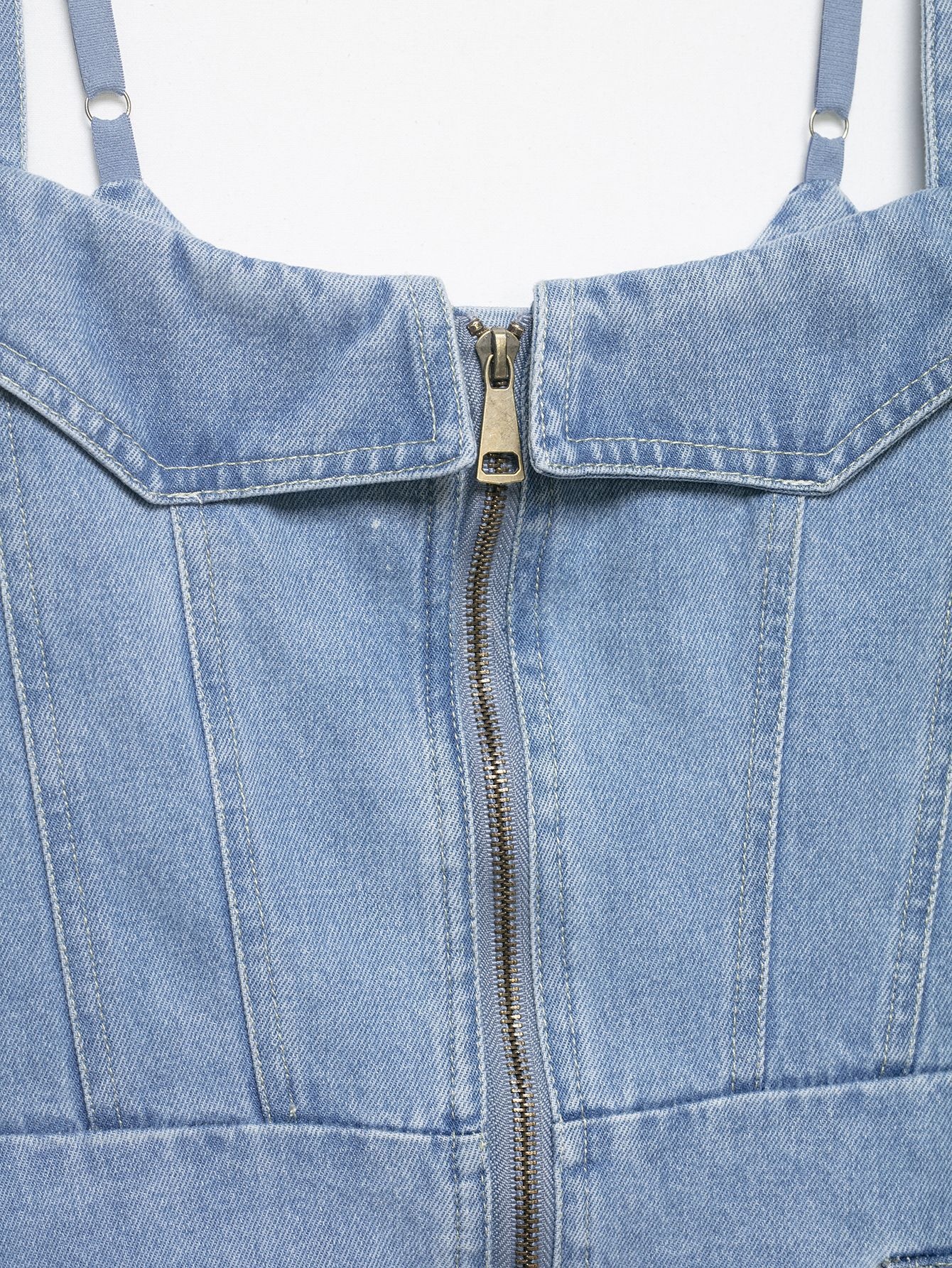 Elegante top a corsetto in denim chiaro con cerniera frontale.