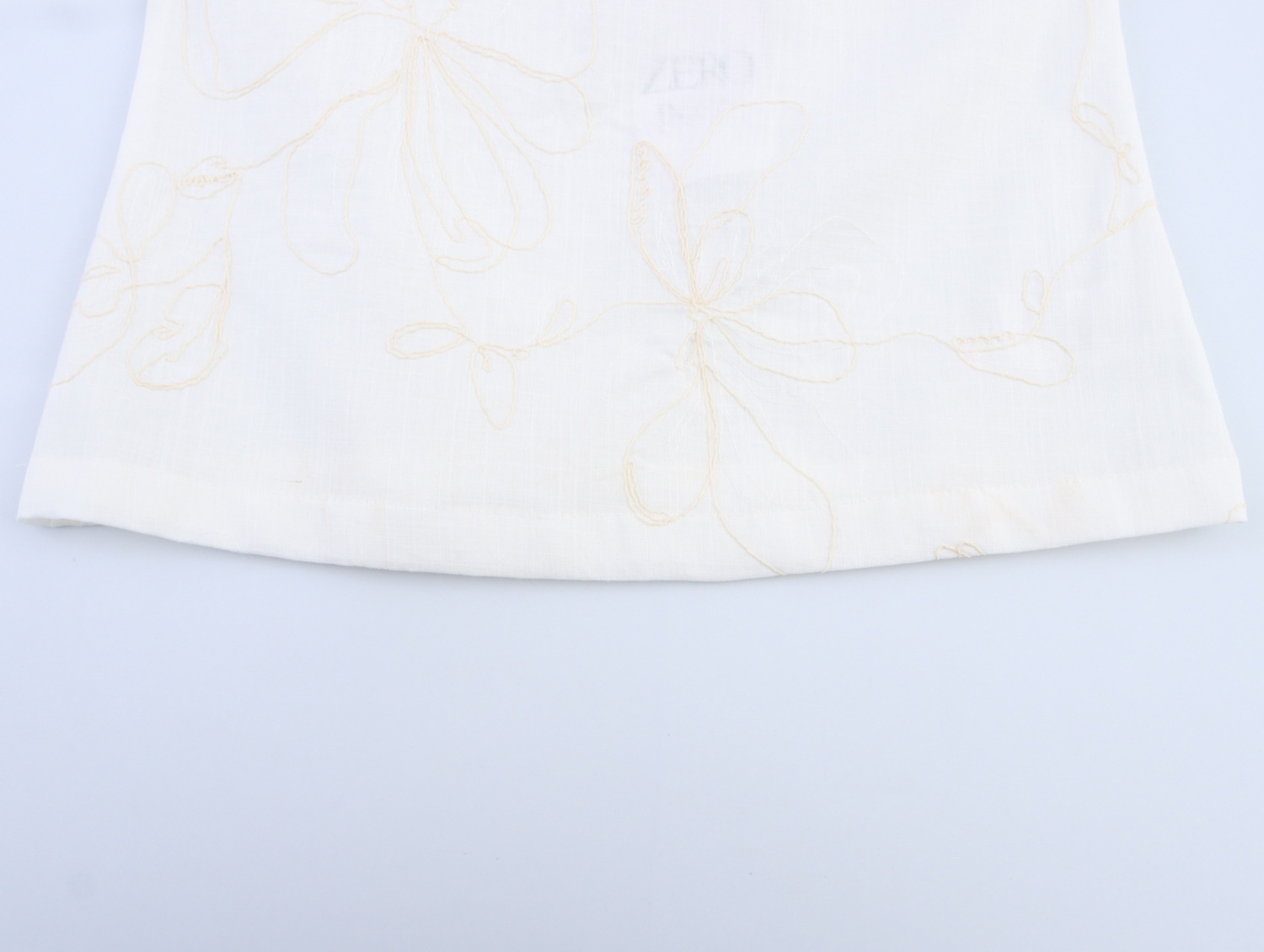 Top a canotta bianco con stampa floreale e laccetti sulle spalle.
