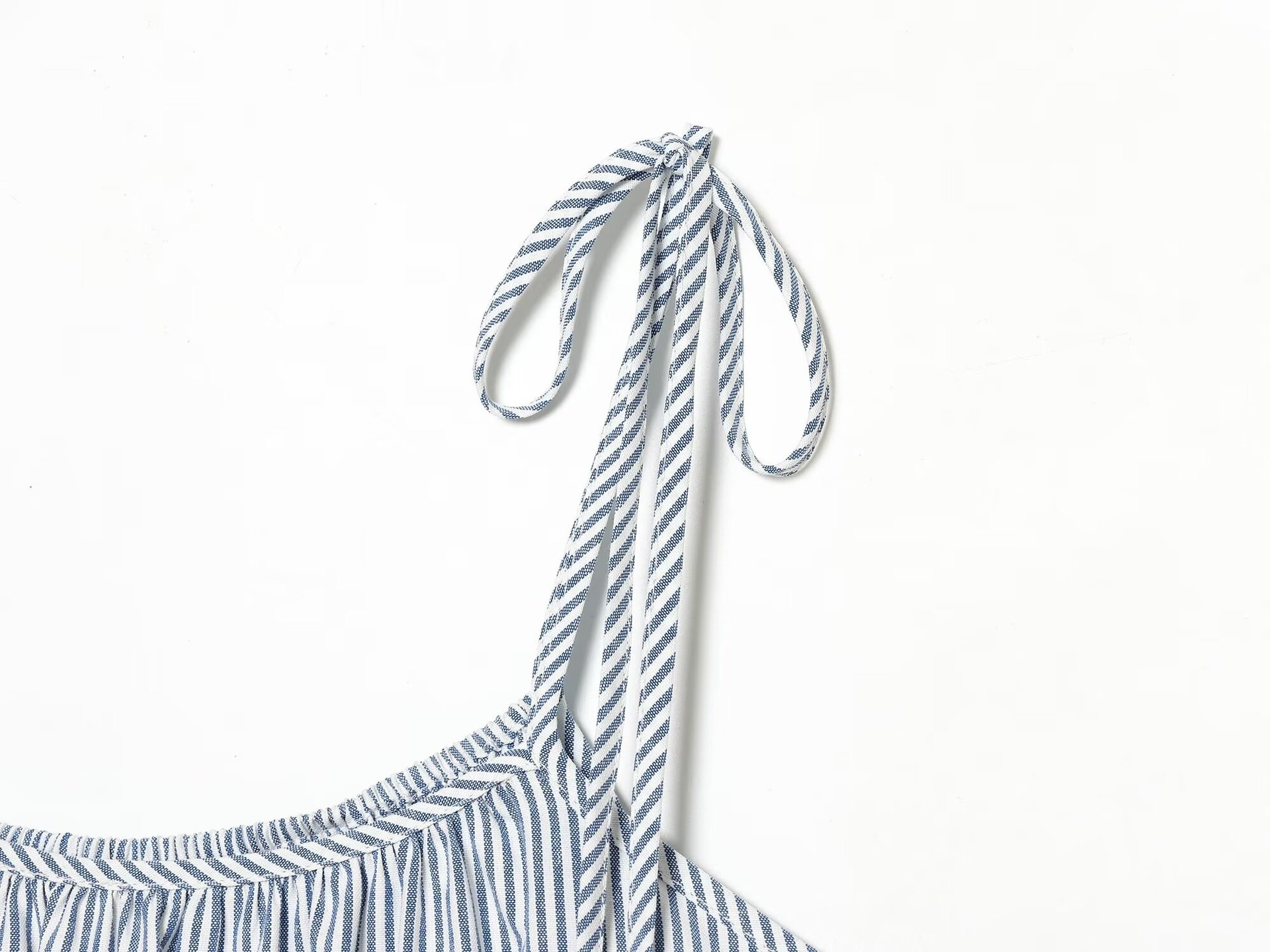 Elegante top a canotta con volant a righe blu e bianche e laccetti sulle spalle.