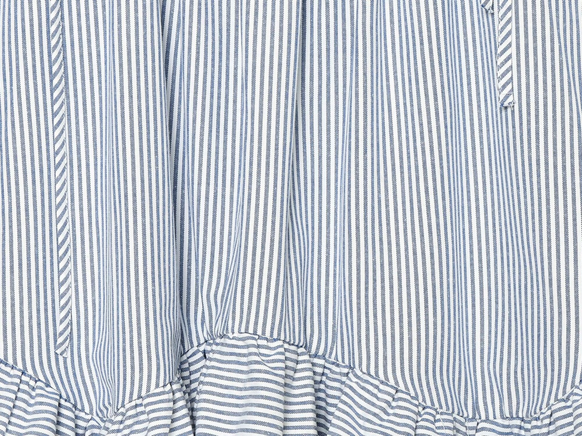 Elegante top a canotta con volant a righe blu e bianche e laccetti sulle spalle.