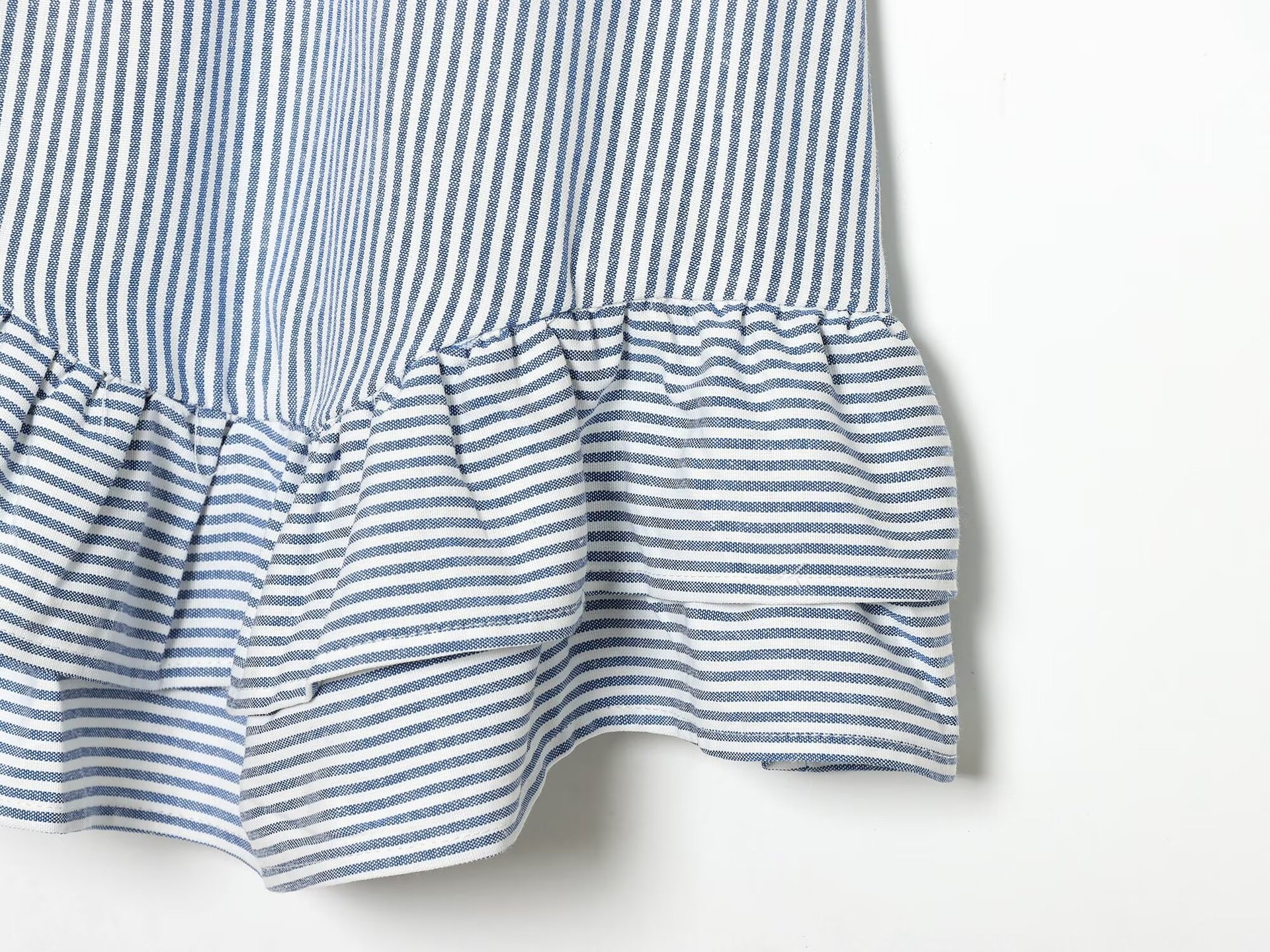 Elegante top a canotta con volant a righe blu e bianche e laccetti sulle spalle.