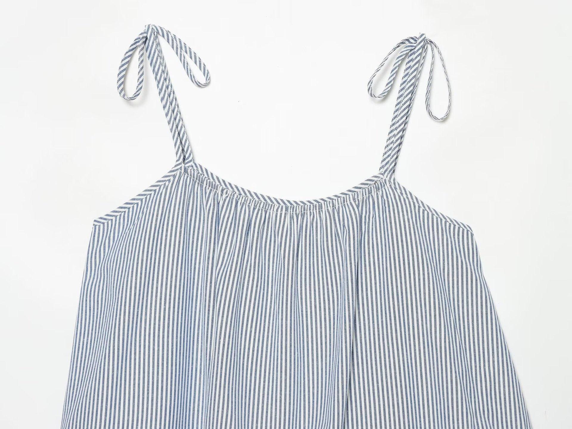 Elegante top a canotta con volant a righe blu e bianche e laccetti sulle spalle.