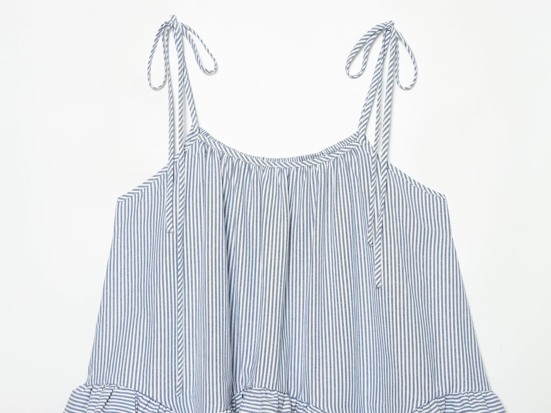 Elegante top a canotta con volant a righe blu e bianche e laccetti sulle spalle.