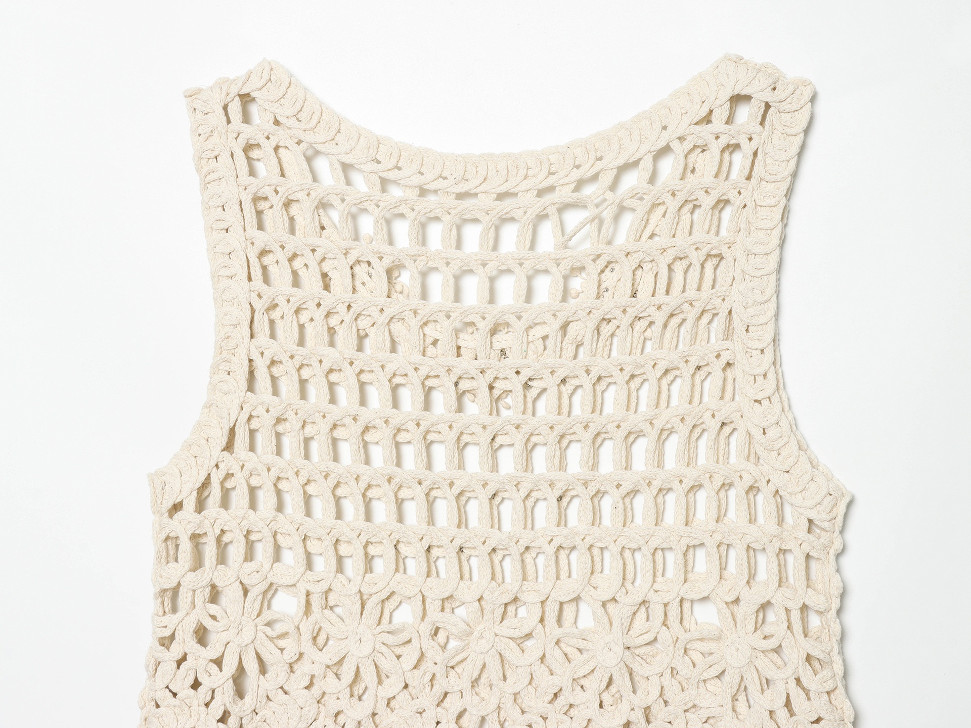 Top corto boho all'uncinetto con frange e decorazioni.