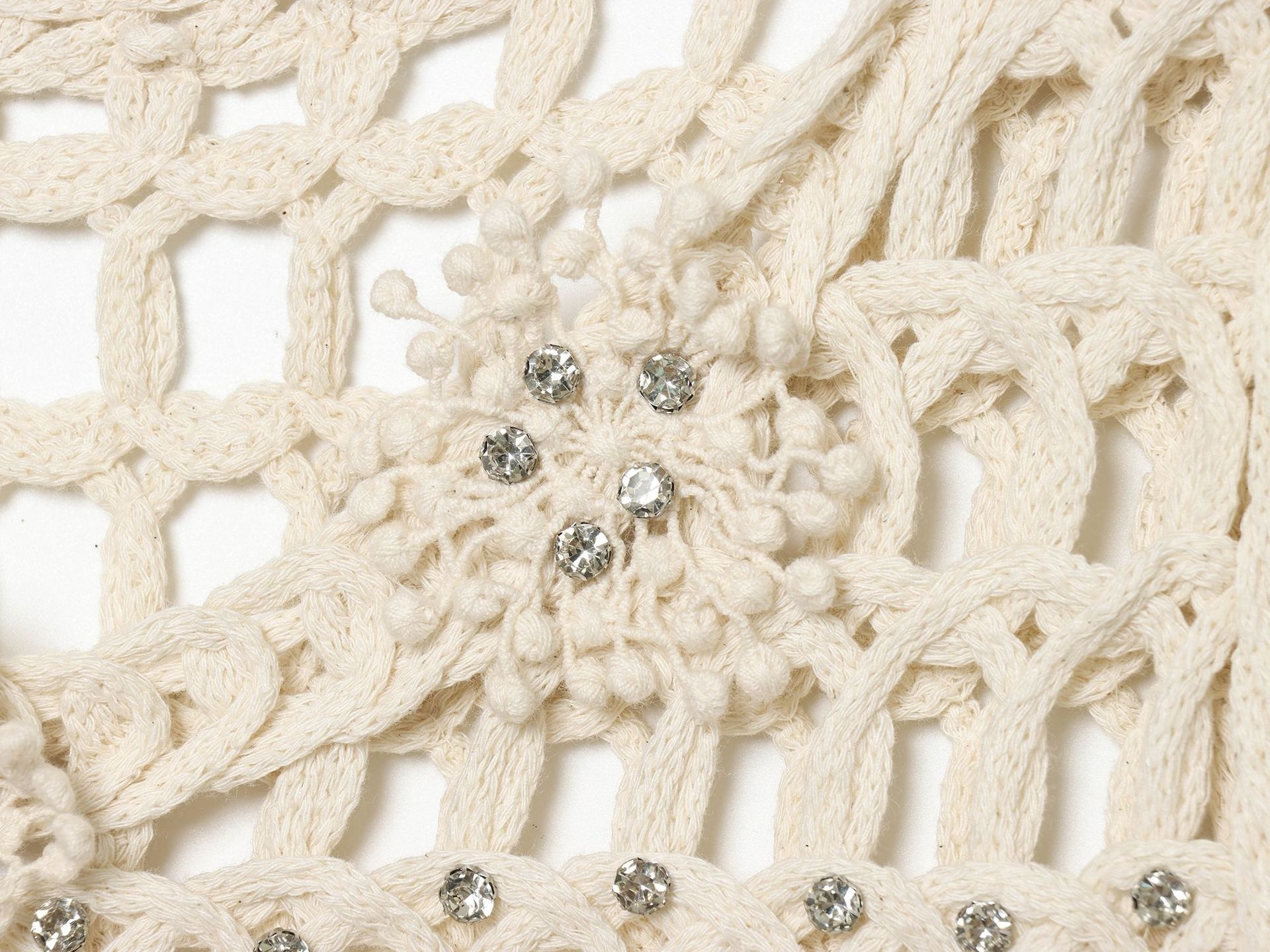 Top corto boho all'uncinetto con frange e decorazioni.