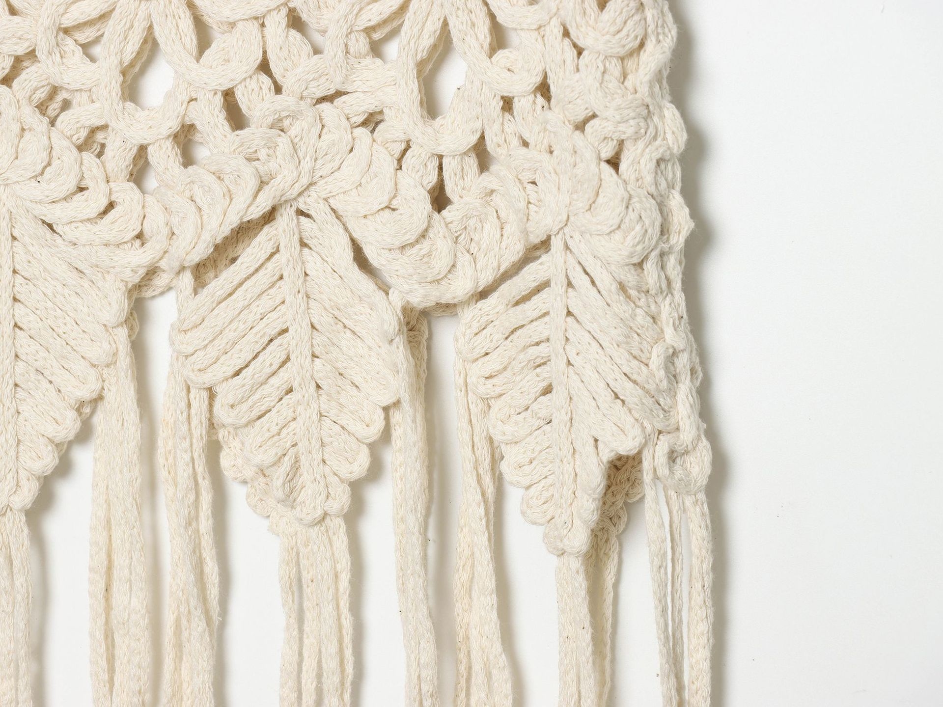Top corto boho all'uncinetto con frange e decorazioni.