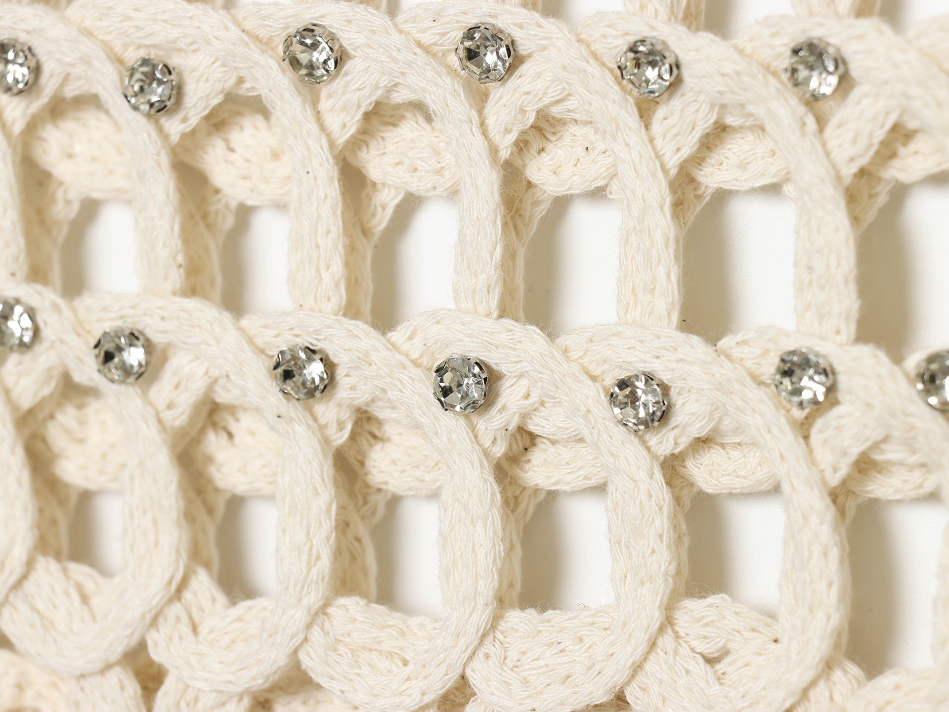 Top corto boho all'uncinetto con frange e decorazioni.