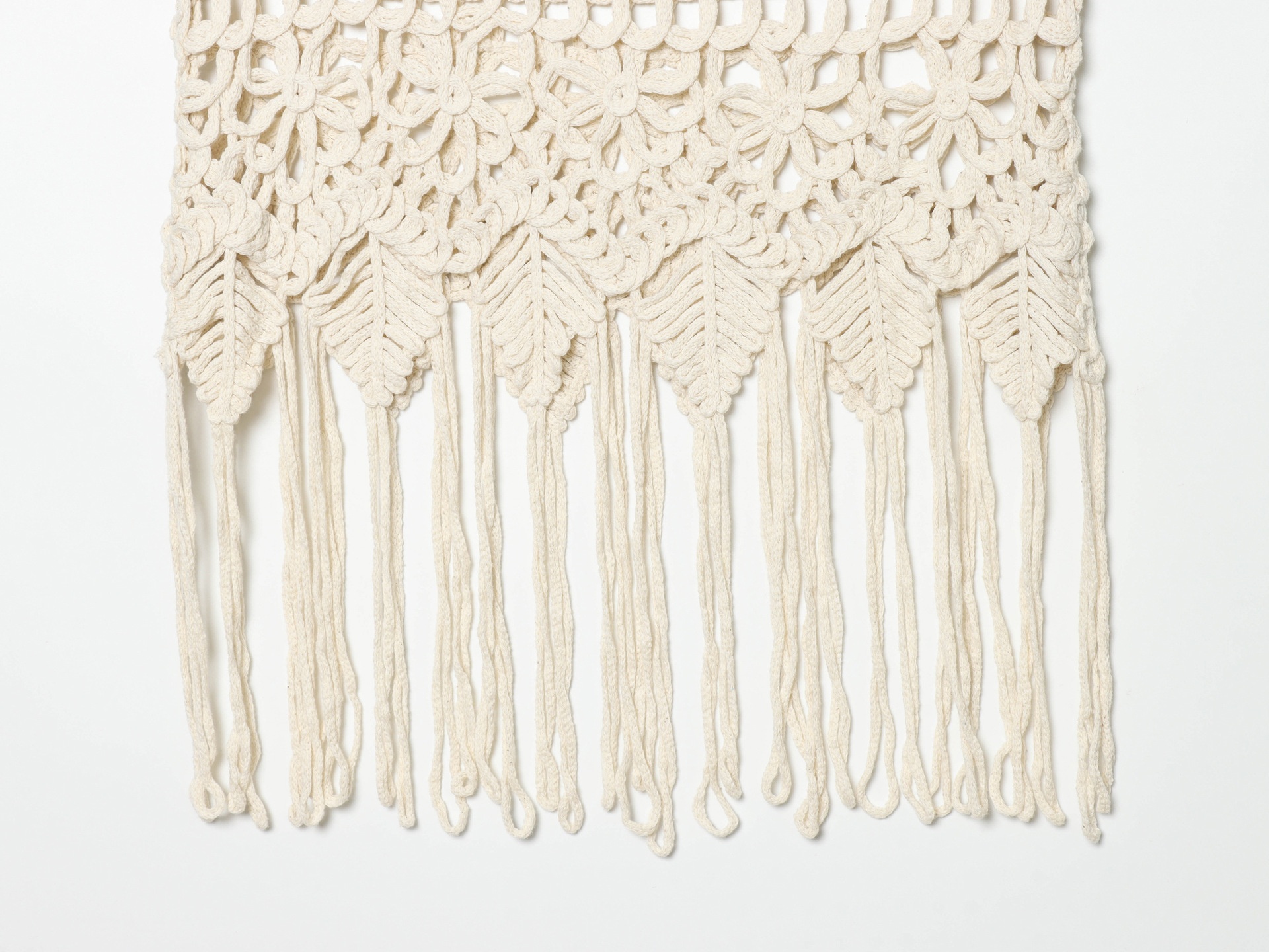 Top corto boho all'uncinetto con frange e decorazioni.