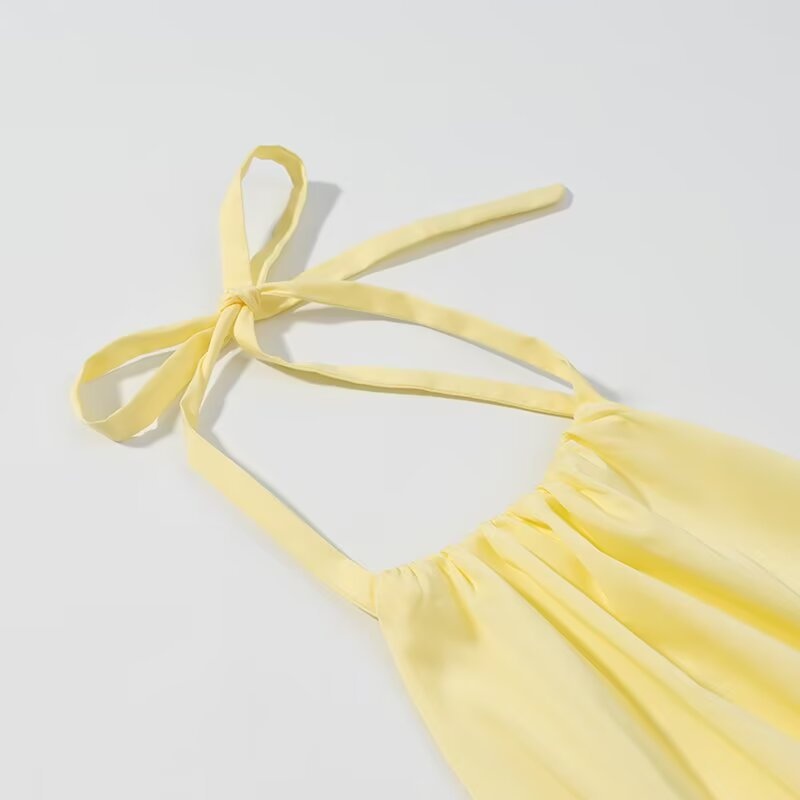 Elegante crop top giallo con scollo all'americana, orlo arricciato e volant.
